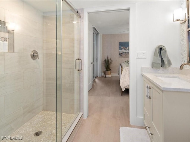 bathroom featuring hardwood / wood-style flooring, vanity, and a shower with shower door