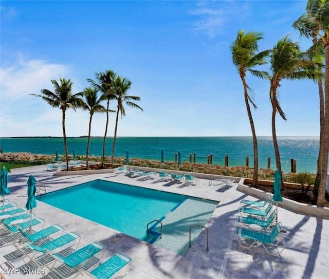 view of pool featuring a water view and a patio area