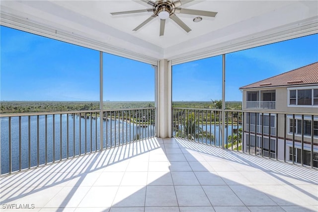 unfurnished sunroom featuring a water view and ceiling fan