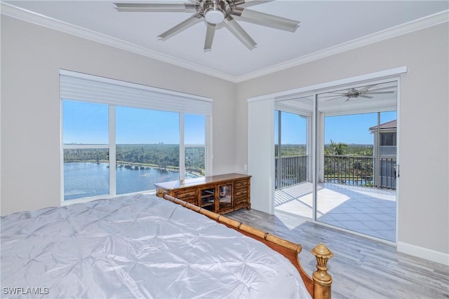 unfurnished bedroom with multiple windows, crown molding, a water view, and access to exterior