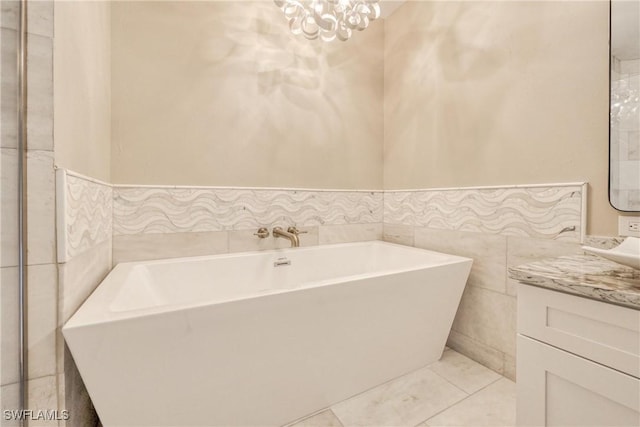 bathroom featuring vanity, a chandelier, tile patterned flooring, and tile walls