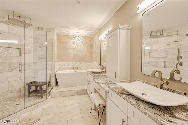 bathroom featuring plus walk in shower, vanity, and an inviting chandelier