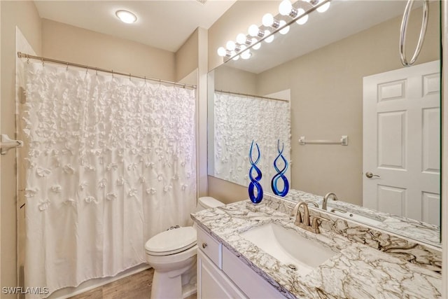 bathroom featuring vanity, hardwood / wood-style flooring, toilet, and a shower with shower curtain