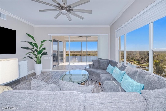 living room featuring crown molding, hardwood / wood-style flooring, ceiling fan, and a water view