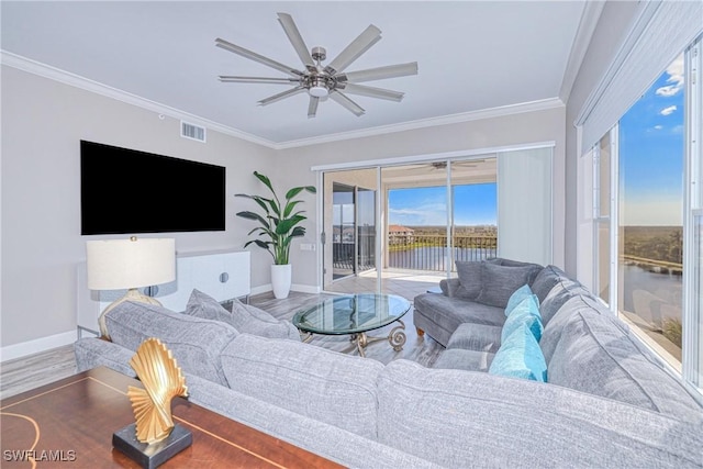 living room with hardwood / wood-style floors, crown molding, ceiling fan, and a water view