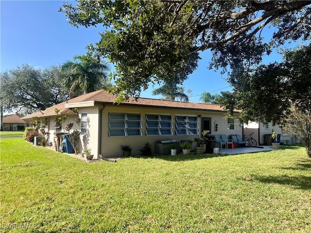 rear view of house with a patio area and a lawn