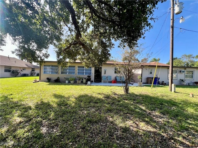 back of property featuring a patio area and a lawn