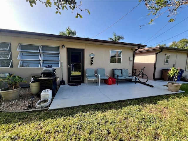 rear view of property featuring a lawn and a patio