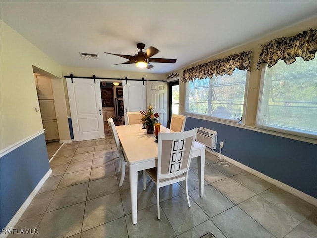 tiled dining room featuring ceiling fan, a barn door, and an AC wall unit