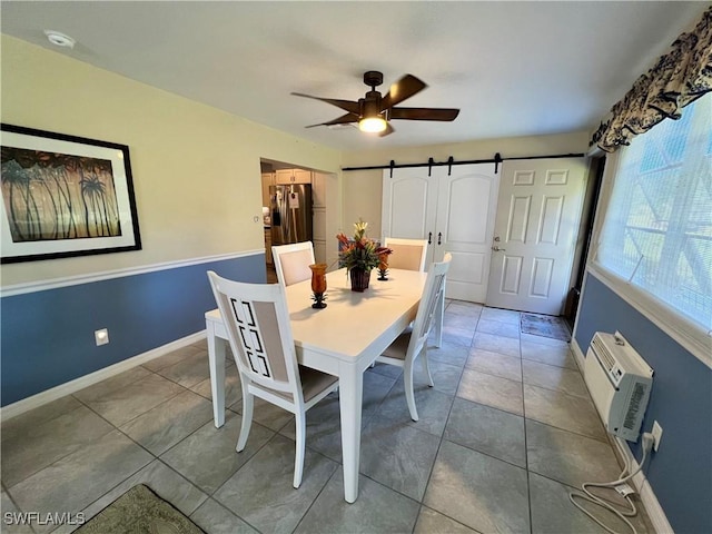 tiled dining area featuring a barn door, a wall mounted air conditioner, and ceiling fan