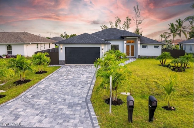 view of front of home featuring a garage and a lawn