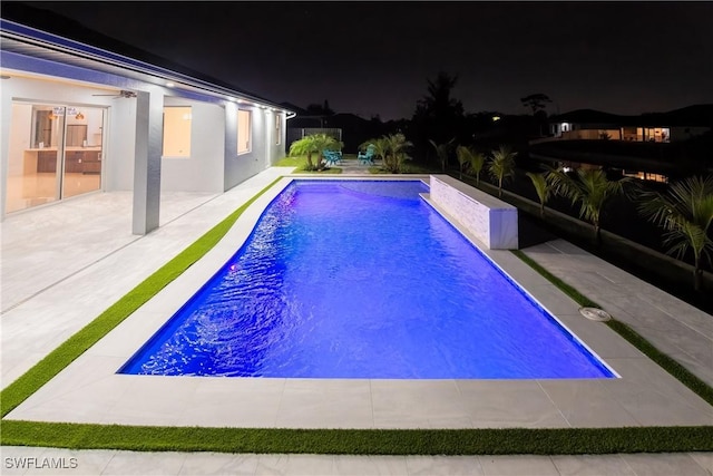 pool at twilight featuring a patio