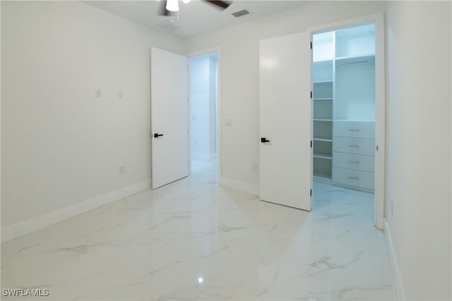 unfurnished bedroom featuring a spacious closet, ceiling fan, and a closet