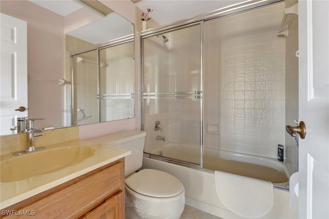 full bathroom featuring vanity, combined bath / shower with glass door, and toilet