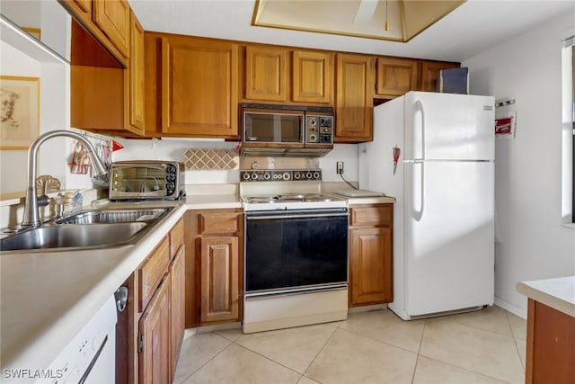 kitchen featuring ceiling fan, sink, light tile patterned floors, and white appliances