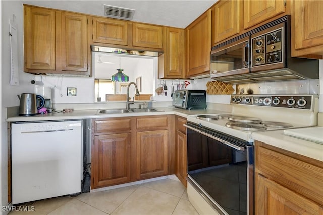 kitchen with sink, light tile patterned floors, and white appliances