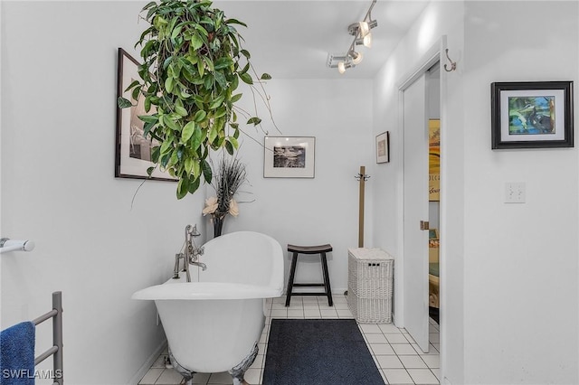 bathroom with rail lighting, tile patterned floors, and a bathtub