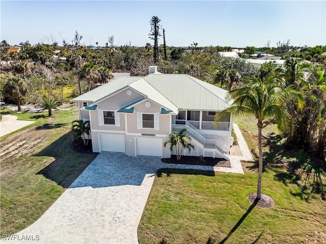 1538 Wilton Ln, Sanibel, FL 33957 - view of front of property with stucco siding, stairs, decorative driveway, a front lawn, and a garage