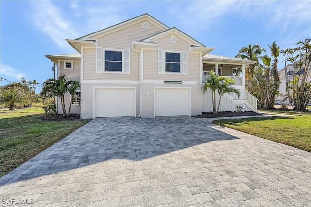1538 Wilton Ln, Sanibel, FL 33957 - beach home with stairs, a front yard, an attached garage, decorative driveway, and a porch