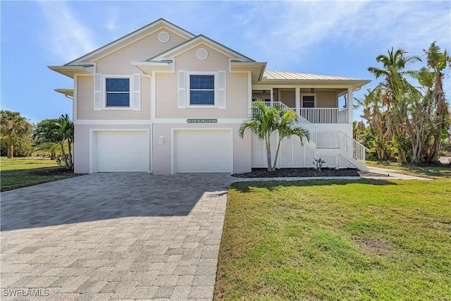1538 Wilton Ln, Sanibel, FL 33957 - view of front of property featuring stairs, an attached garage, decorative driveway, a front lawn, and a porch