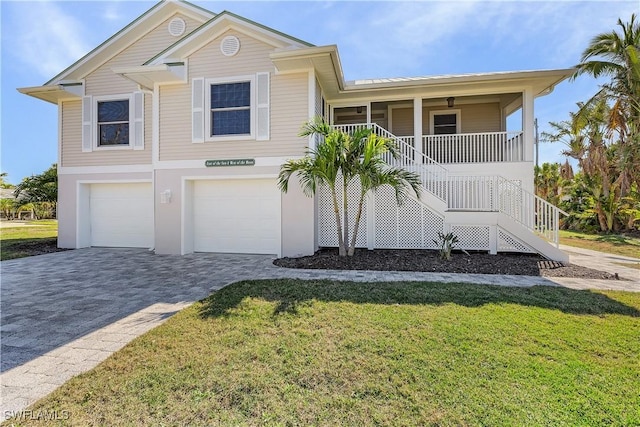 1538 Wilton Ln, Sanibel, FL 33957 - view of front of home featuring stairs, a front yard, a garage, decorative driveway, and a porch