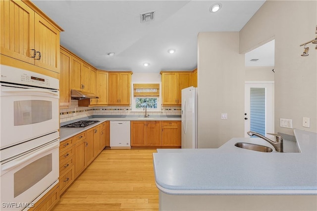 1538 Wilton Ln, Sanibel, FL 33957 - kitchen with white appliances, light wood-style floors, under cabinet range hood, and a sink