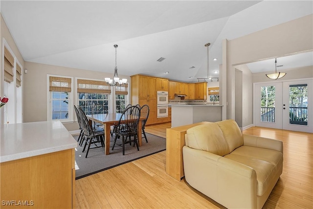 1538 Wilton Ln, Sanibel, FL 33957 - dining room featuring vaulted ceiling, french doors, light wood-type flooring, visible vents, and an inviting chandelier