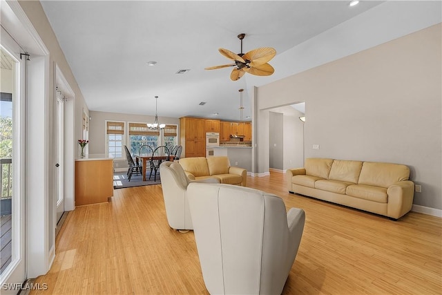 1538 Wilton Ln, Sanibel, FL 33957 - living room with light wood finished floors, lofted ceiling, baseboards, ceiling fan with notable chandelier, and visible vents