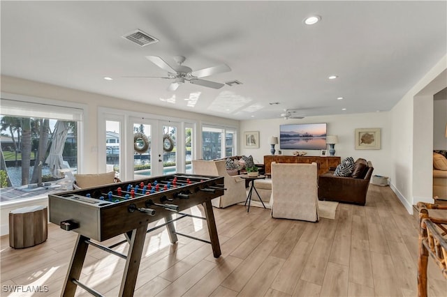 game room with light hardwood / wood-style flooring, ceiling fan, and french doors