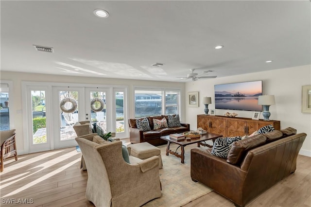 living room with ceiling fan, light hardwood / wood-style floors, and french doors