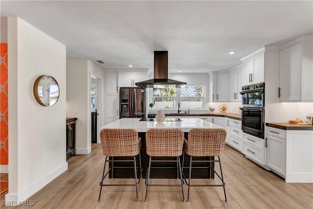 kitchen with white cabinets, a kitchen bar, island exhaust hood, a center island, and black appliances