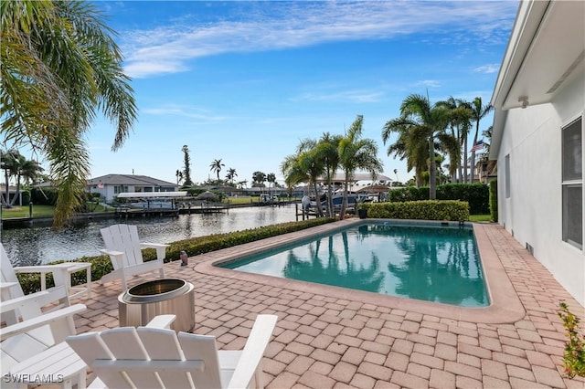 view of swimming pool featuring a water view, an outdoor fire pit, and a patio