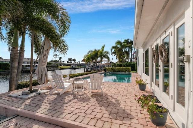 view of pool with a water view and a patio area