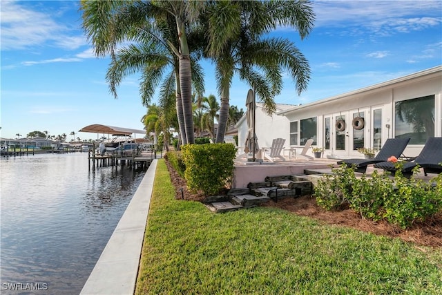 dock area featuring a water view and a lawn