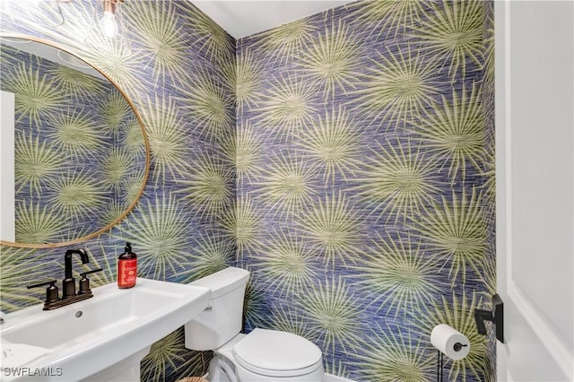 bathroom featuring tile walls, sink, and toilet