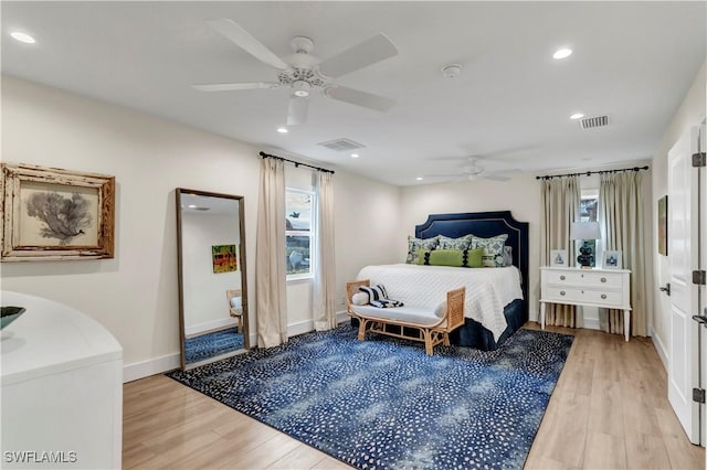 bedroom with ceiling fan, light hardwood / wood-style floors, and multiple windows