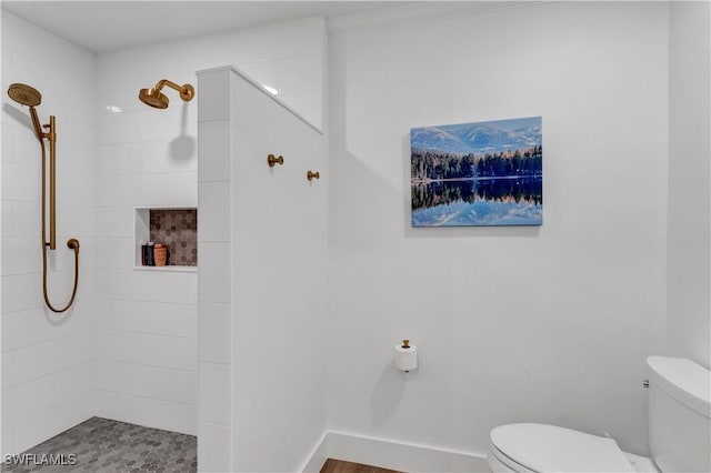 bathroom featuring a tile shower and toilet