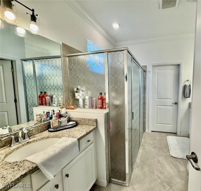 bathroom featuring ornamental molding, vanity, and a shower with shower door