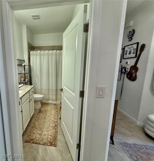 bathroom featuring walk in shower, tile patterned floors, vanity, and toilet