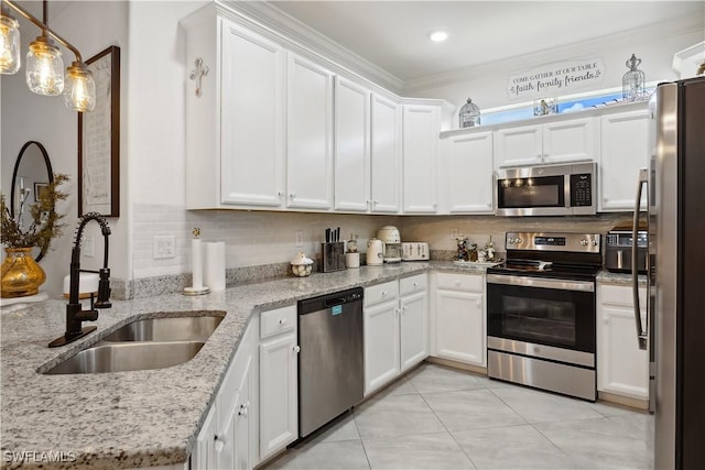 kitchen featuring hanging light fixtures, appliances with stainless steel finishes, sink, and white cabinets