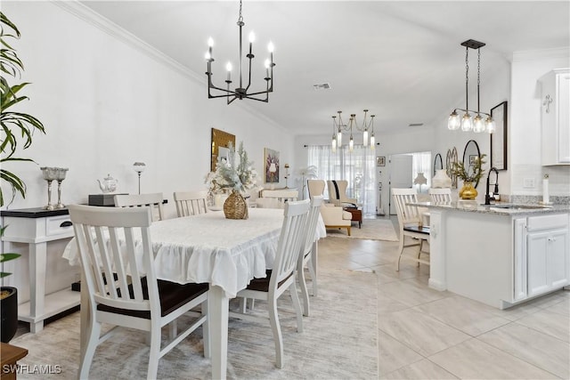 dining area with crown molding, sink, light tile patterned flooring, and a chandelier