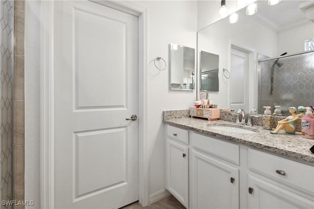 bathroom featuring ornamental molding, vanity, and a tile shower