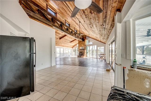 kitchen featuring a wealth of natural light, wooden ceiling, ceiling fan, and black fridge