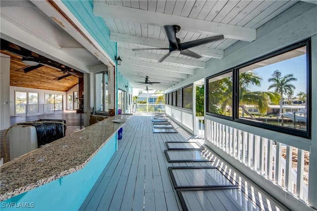 wooden terrace featuring an outdoor bar and ceiling fan