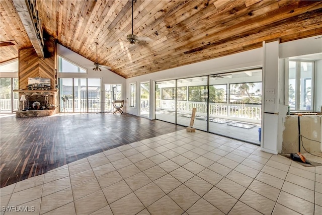 unfurnished living room featuring ceiling fan, a stone fireplace, high vaulted ceiling, and wooden ceiling