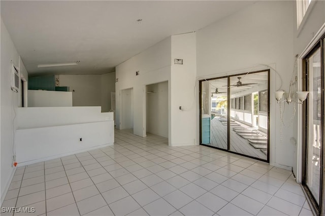 tiled spare room featuring high vaulted ceiling