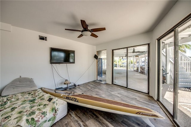 unfurnished bedroom featuring multiple windows, hardwood / wood-style floors, and access to outside