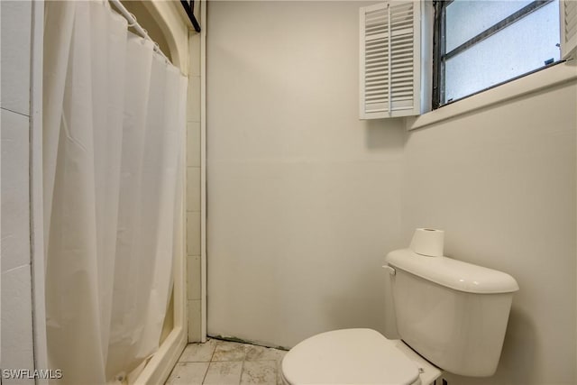 bathroom featuring curtained shower and toilet