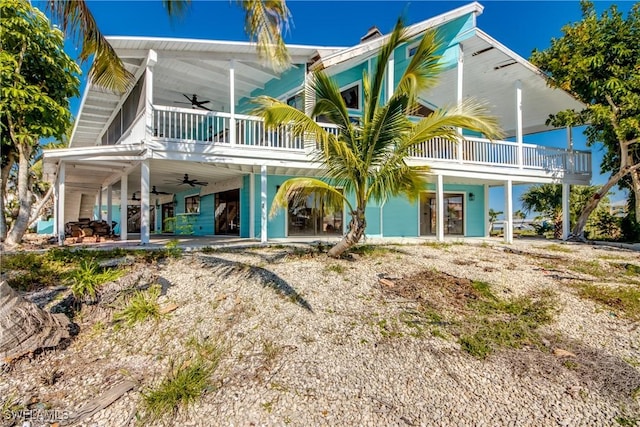 rear view of property with a patio, a balcony, and ceiling fan