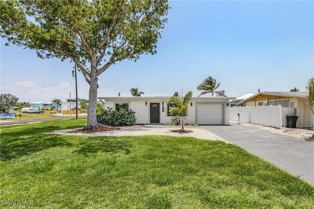 single story home featuring a garage and a front yard